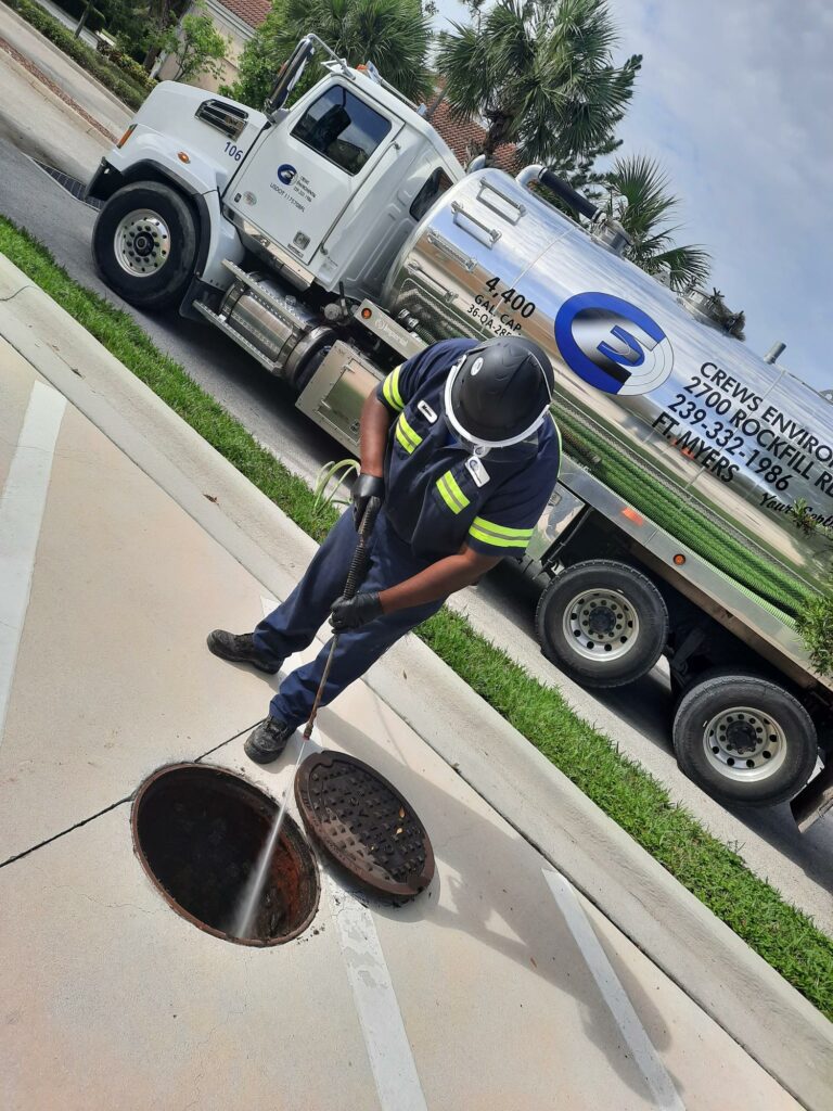Technician performing septic tank pumping service at home